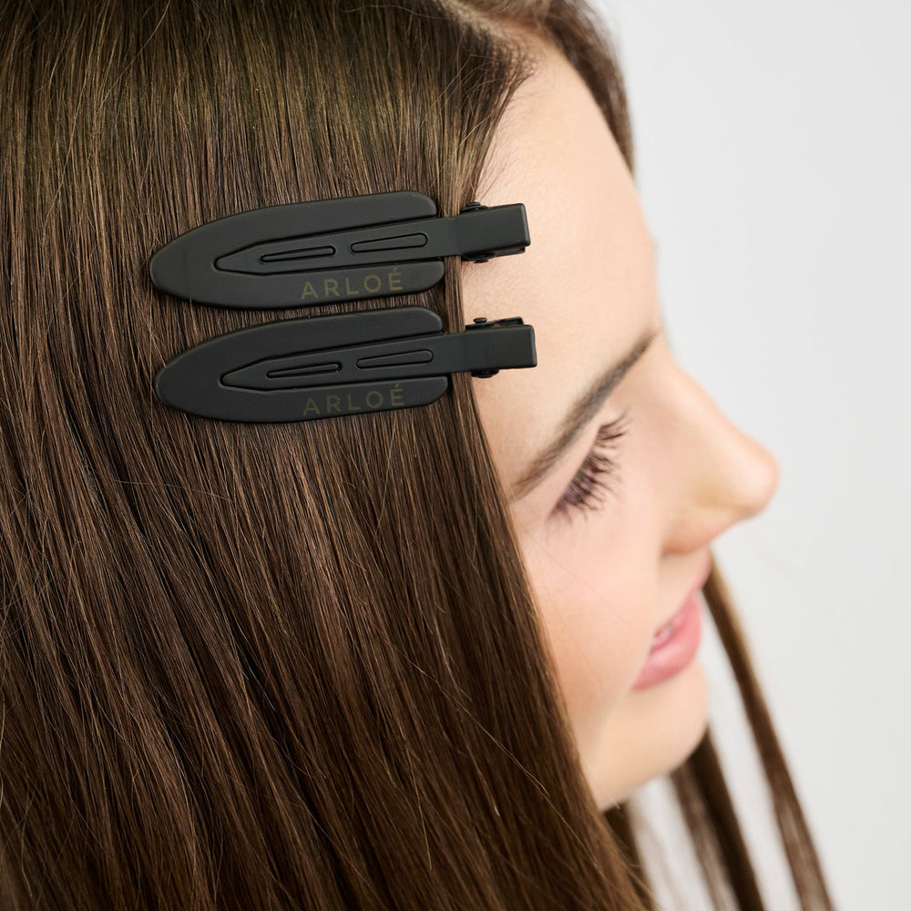 Two black hair clips with 'ARLOE' branding on a white background