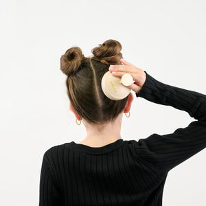 Girl massaging their hair with a massager on a white background