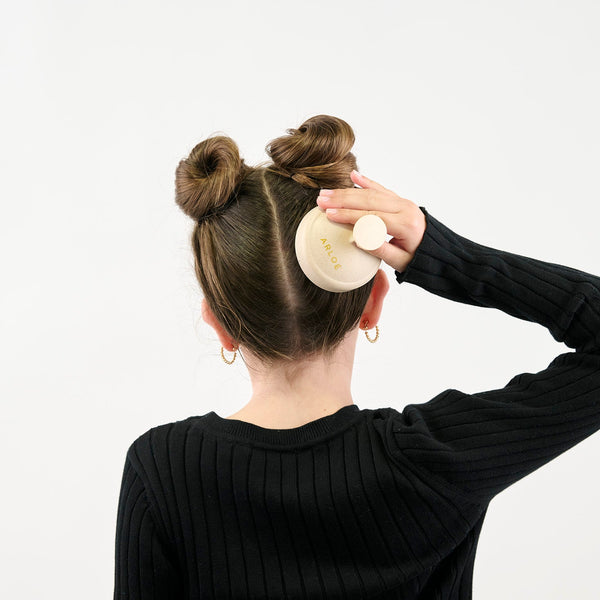 Girl massaging their hair with a massager on a white background