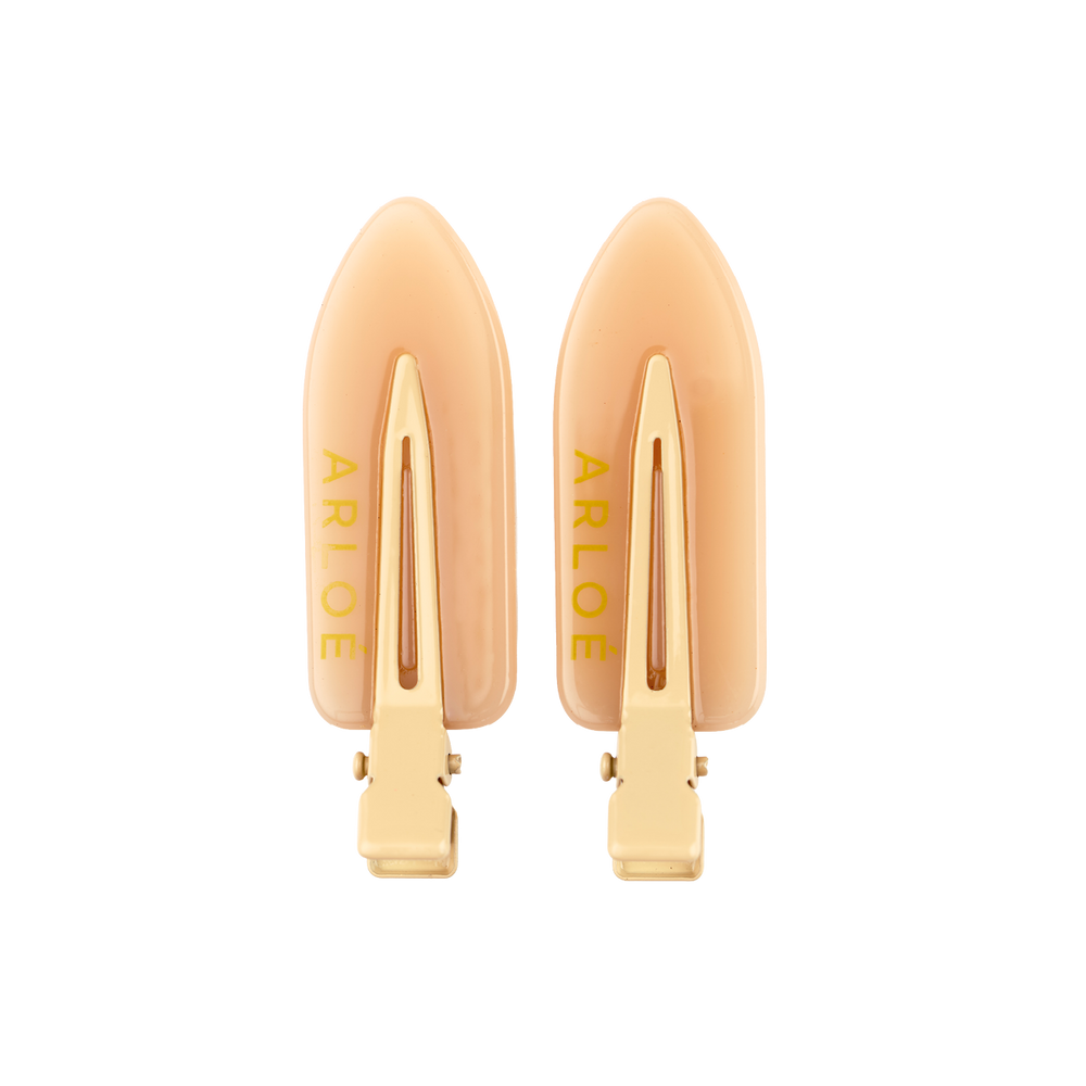 Pair of gold hair clips with 'ARLOE' branding on a white background