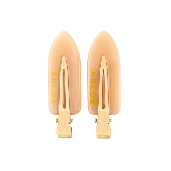 Pair of gold hair clips with 'ARLOE' branding on a white background
