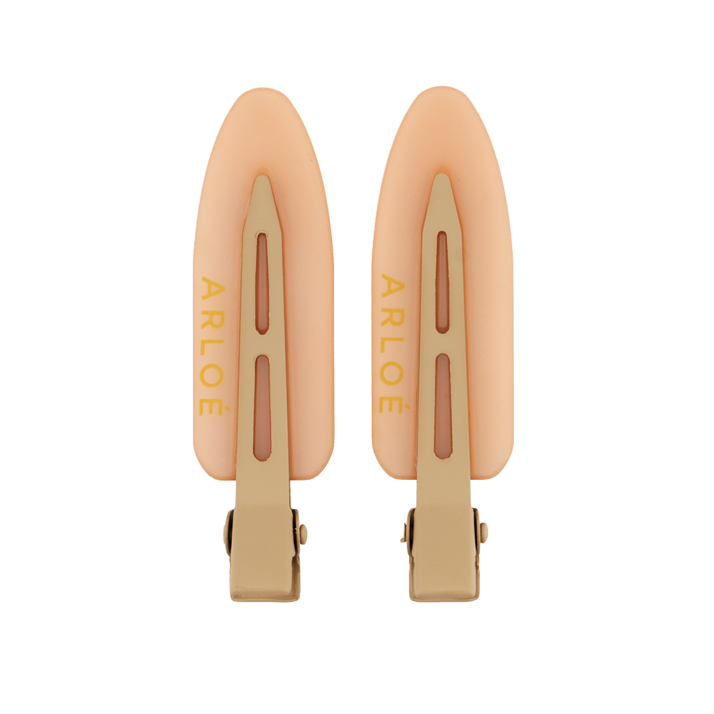 Two peach-colored hair clips with gold accents on a white background, branded 'ARLOE'.