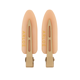 Two peach-colored hair clips with gold accents on a white background, branded 'ARLOE'.